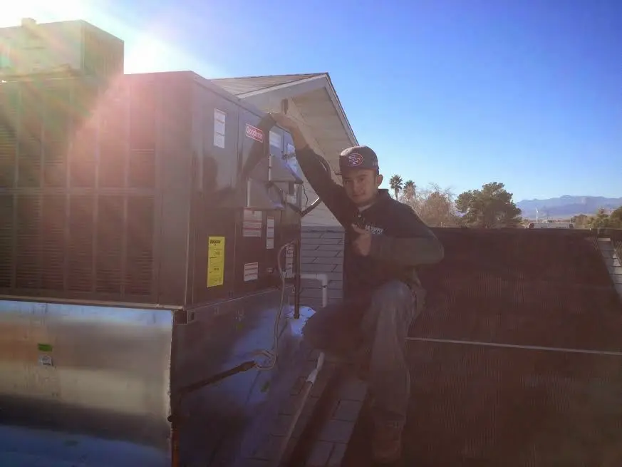 HVAC technician performing AC Tune-Up on a rooftop unit in Worcester